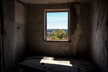 Fototapeta na wymiar Window from weathered abandoned room to sunny day