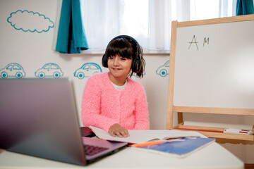 Cute girl with headphone , learning online at home