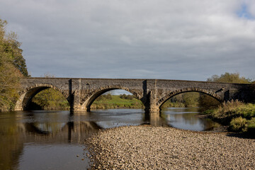Fototapeta premium Brungerley bridge, Clitheroe. Large stone bridge over the river Ribble with reflections in the water