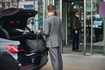 Man in a face mask staring at his chauffeur