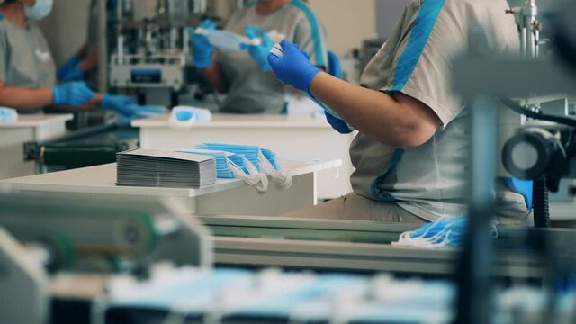Female workers stacking masks at a medical mask manufacturing facility