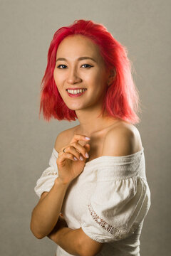 Portrait Of An Asian Woman With Creative Hair Coloring Bright Red, Pink. Beautiful Young Girl With Scarlet Hair Close Up