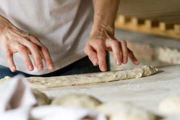 Close up image of cook hands kneading the dough for pies