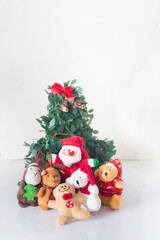 some dolls like reindeer bears cookies and christmas decorations next to santa claus have fun around a christmas tree in the prosperity of the new year in white background