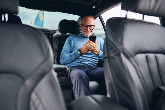 Passenger With A Cellphone Sitting In The Car