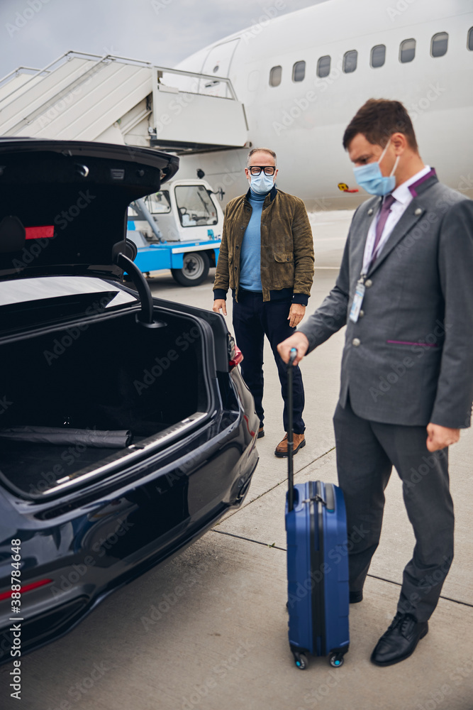 Wall mural Passenger staring at a young man with his luggage