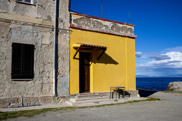 Corner of an old abandoned house on the seashore. Pianosa Island, Italy.