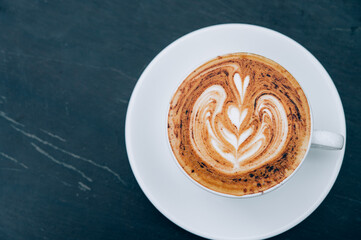 A Cup of hot latte art coffee on wooden table