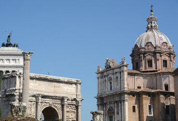 Obraz premium In the center of Rome, the ancient Roman Forum with the Septimius Severus Arch and the Baroque facade of the Saints Luca e Martina church.