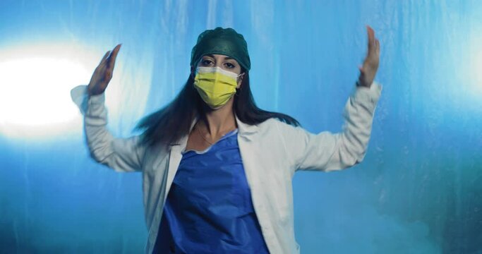 Medico balla con mascherina e camice bianco. Coronavirus sconfitto.