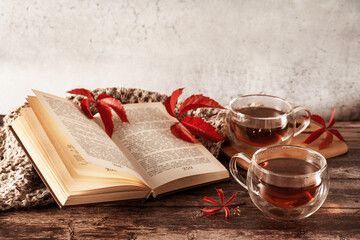 Beautiful rustic template of two cups of tea and book on wooden background. Cozy natural autumn background. Autumn concept. Flat lay style. Vintage card with fall background for concept design.