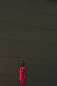 Man Wearing Pink Suit With Architectural Background 