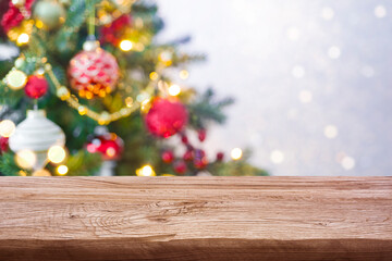 Holiday background concept of wooden table against decorated Christmas tree