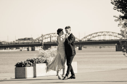 Young Couple Dancing Tango Against The Old City Background. Travel And Lifestyle Concepts. Black And White Photo