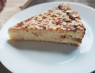 Fresh baked golden piece of apple pie on white plate at kitchen