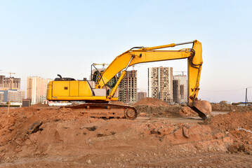 Fototapeta na wymiar Excavator during excavation and road construction works at construction site on sunset background. Backhoe on foundation work in sand pit. Tower crane on constructing new building