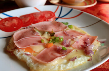 Delectable homemade fried eggs with ham and chopped vegetable