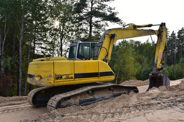 Excavator during construction new road in forest area. Backhoe at groundwork. Earth-moving...