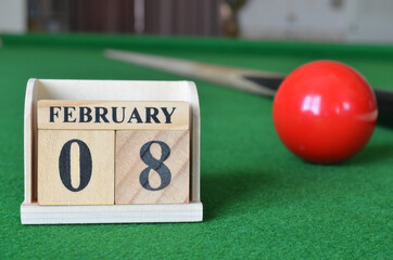 February 8, number cube with balls on snooker table, sport background.