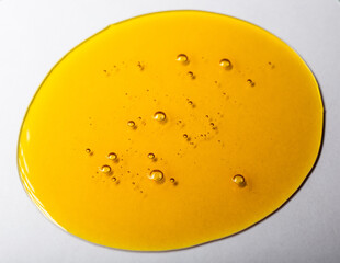 Yellow viscous liquid lecithin with bubbles on glass