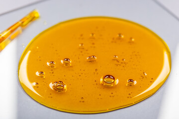 Yellow viscous liquid lecithin with bubbles on glass - 388798435
