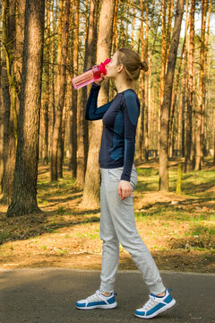 Sports girl crouches in the woods. The girl is warming up. Sports girl goes in for sports