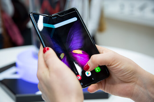 Moscow, Russia - October 04, 2019: female hands holding a new flagship smartphone Samsung Galaxy Fold with flexible display. close up. backgtound in blur
