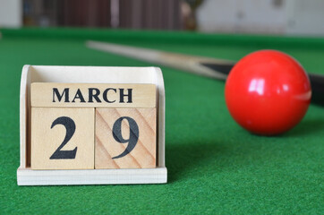 March 29, number cube with balls on snooker table, sport background.