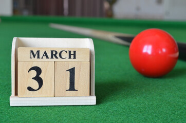 March 31, number cube with balls on snooker table, sport background.