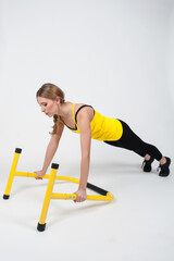 Obraz premium Woman doing exercises with high yellow floor bars on a white background