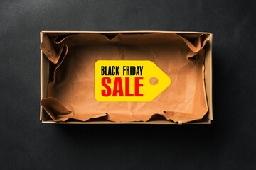 Black Friday sale. Open empty box with a tag on a dark background.