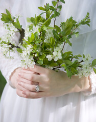Hands of bride holding spring flowers bouquet. 