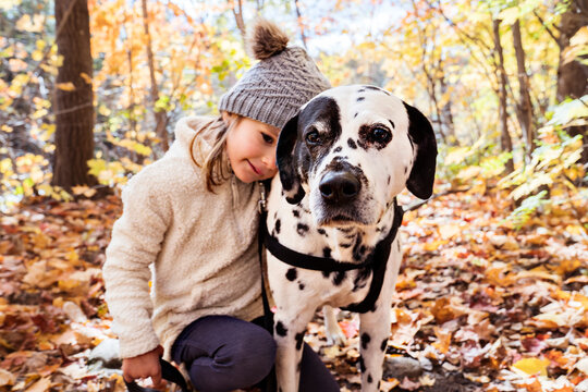 girl with dalmatians dog on autumn season