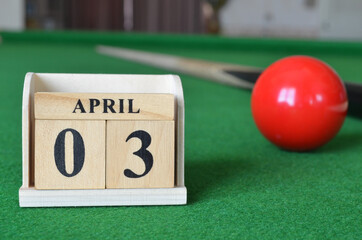 April 3, number cube with balls on snooker table, sport background.
