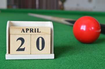 April 20, number cube with balls on snooker table, sport background.