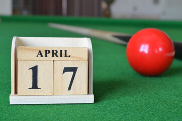 April 17, number cube with balls on snooker table, sport background.