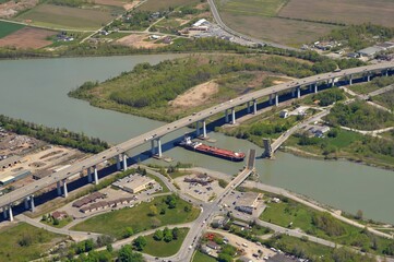 aerial view of the Welland Canal in St Catharines Ontario, ship passing under neath the Garden City highway bridge with the Homer drawbridge open