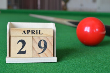 April 29, number cube with balls on snooker table, sport background.