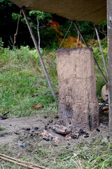 Close up on a clay chimney or temporary oven made in order to melt some metal and make weapons seen inside of a tent of a blacksmith during a Polish historic fair on a sunny summer day