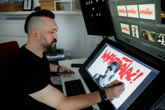 An artist Kubicki who has redesigned an iconic Polish campaign poster from the 1989 election, Poland's first democratic vote after World War Two, to mark massive abortion rights protests sweeping through the country, works at his home in Warsaw
