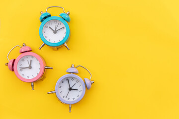 Simply minimal design three ringing twin bell classic alarm clock Isolated on yellow background. Rest hours time of life good morning night wake up awake concept. Flat lay top view copy space