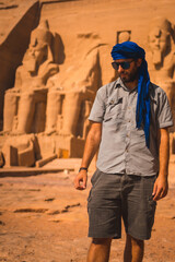 Portrait of a young tourist with a blue turban visiting the Abu Simbel Temple in southern Egypt in Nubia next to Lake Nasser. Temple of Pharaoh Ramses II, travel lifestyle