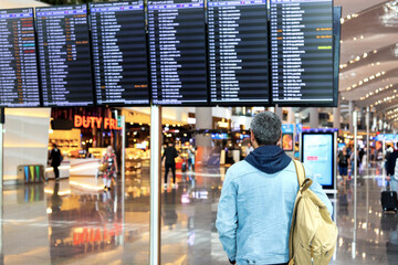 A passenger looks at the departure Board at the airport İstanbul Havalimanı. Turkey Istanbul...