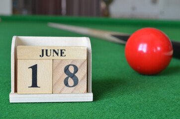 June 18, number cube with balls on snooker table, sport background.