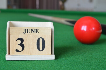 June 30, number cube with balls on snooker table, sport background.