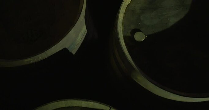 Round wood keg barrels cask whisky alcohol wine cellar dark warehouse overhead view