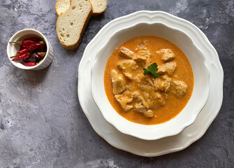 Traditional Hungarian chicken goulash, also known as chicken paprikash, or paprika chicken, in juicy paprika sour cream sauce and parsley.