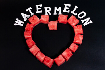 Diced slices of ripe watermelon are arranged in a heart shape. Ad at the top.