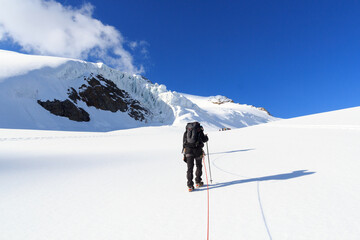 Rope team mountaineering with crampons on glacier Taschachferner towards Wildspitze and mountain...