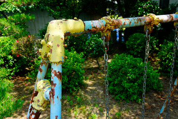 公園の老朽化したブランコの鉄パイプ